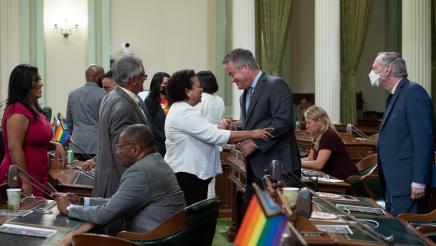 Assemblymember O'Donnell shakes hands with Assemblymember Bonta while others wait in line to greet him